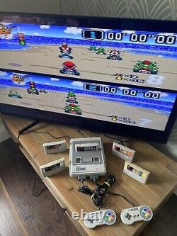 Console Super Nintendo SNES avec bundle comprenant 2 manettes, 5 jeux Mario Kart All Stars en parfait état.