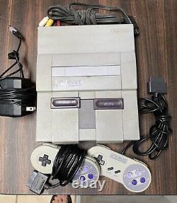 Console de jeu Super Nintendo SNES avec câbles et 2 manettes originales testées.
