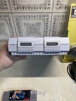 Super Nintendo SNES Console de salon grise. Livré avec une nouvelle manette et des jeux.